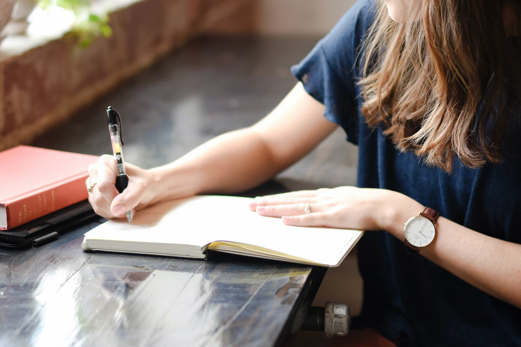 Eine junge Frau mit Stift und Notizbuch